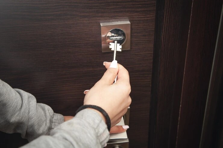 kvinnelig hånd som låser opp døren med nøkkel